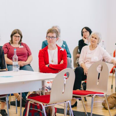 Acht Frauen hören gespannt und ergriffen zu.