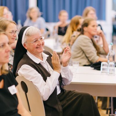 Eine Ordensfrau klatscht.