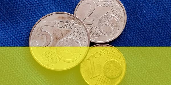 Geldmünzen auf blau-gelben Hintergrund.
