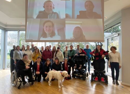 Eine Fotomontage mit folgenden zwei Bildern: Foto von einer Gruppe mit 25 Personen und einem Hund sowie Foto von vier Frauen in Zoom-Kacheln auf einer Leinwand im Seminarraum.